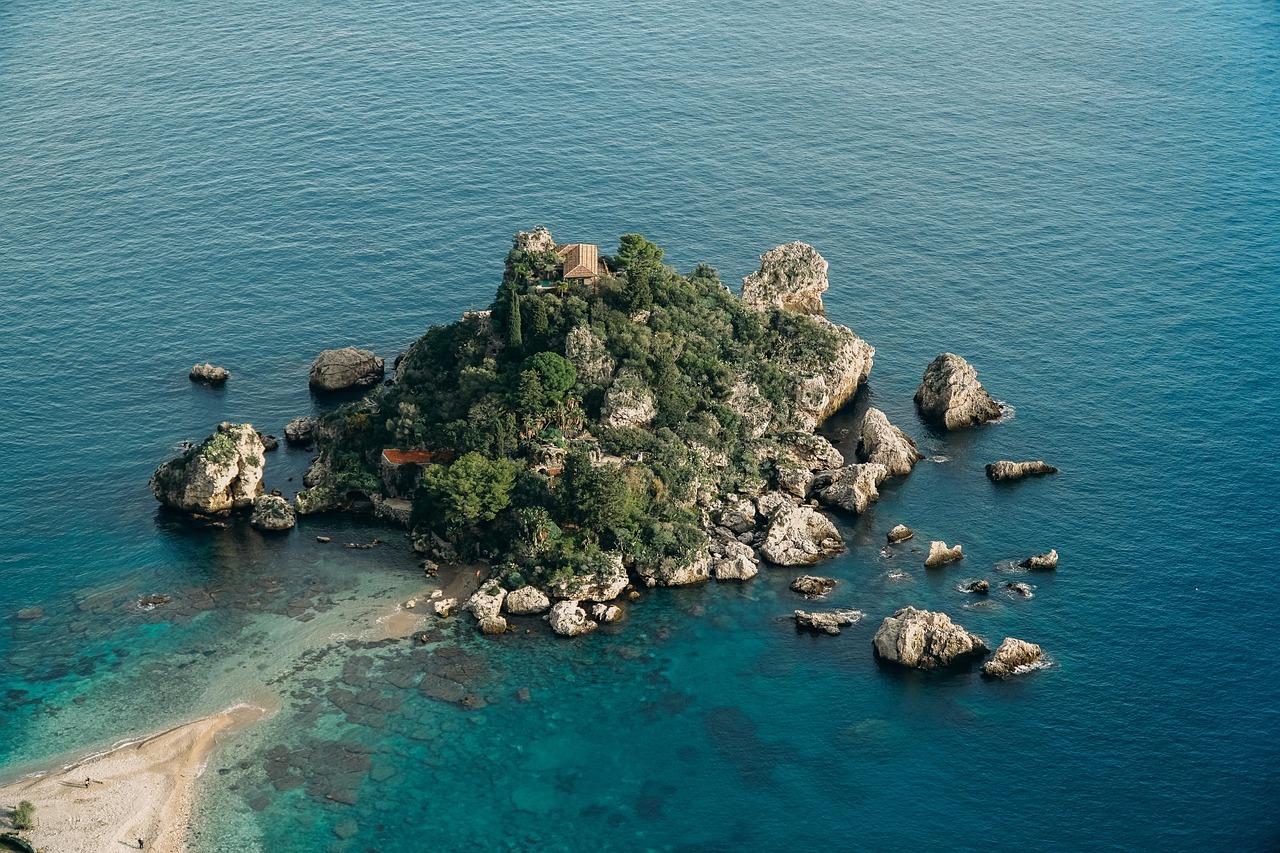 Luftaufnahme von Isola Bella bei Taormina in Sizilien mit türkisblauem Ionischen Meer, kleiner Inselbucht und felsiger Küstenlandschaft.