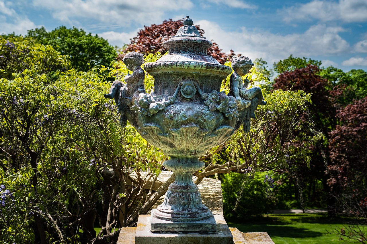 Garten der Villa Comunale di Taormina mit großer dekorativer Vase im Vordergrund, umgeben von mediterraner Parklandschaft in Taormina