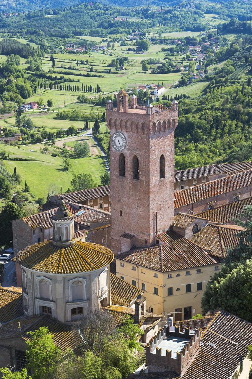 Blick über die historische Altstadt von San Miniato mit dem mittelalterlichen Turm Torre di Federico II., roten Ziegeldächern und der grünen Hügellandschaft der Toskana.