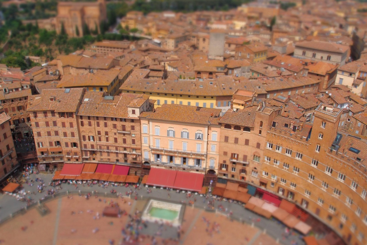 Panoramablick auf die historische Altstadt von Siena mit terrakottafarbenen Dächern und der berühmten Piazza del Campo.
