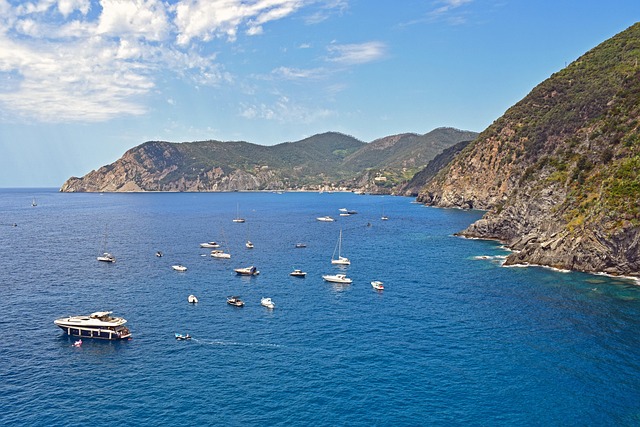 Kleine Boote auf dem klaren Wasser vor der malerischen ligurischen Küste mit mediterraner Landschaft, felsigen Ufern und typisch italienischem Küstenflair.