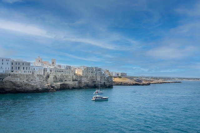 Blick auf die Küstenstadt Polignano a Mare in Apulien mit Booten auf der Adria.