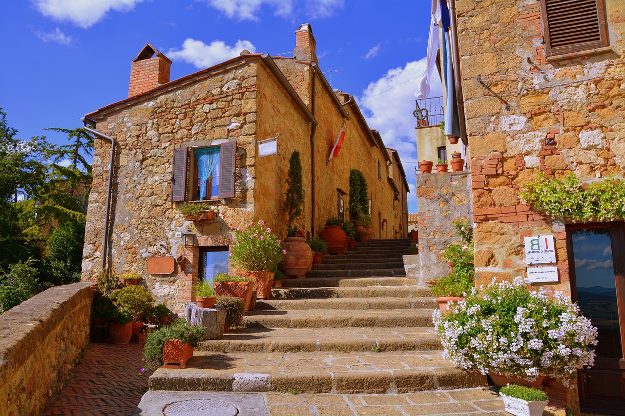 Historische Steinhäuser und Treppen in einer malerischen Gasse eines traditionellen Dorfes in der Toskana, Italien.