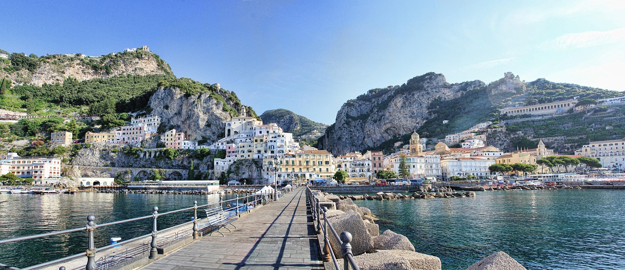 Amalfi an der Amalfiküste mit bunten Häusern, steilen Felsen und Hafenpromenade in Kampanien, Italien