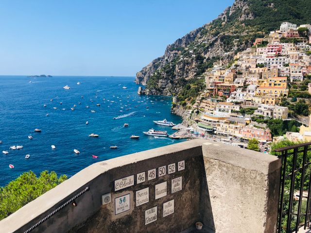 Blick auf Positano an der Amalfiküste mit bunten Häusern, steilen Felsen und türkisblauem Meer