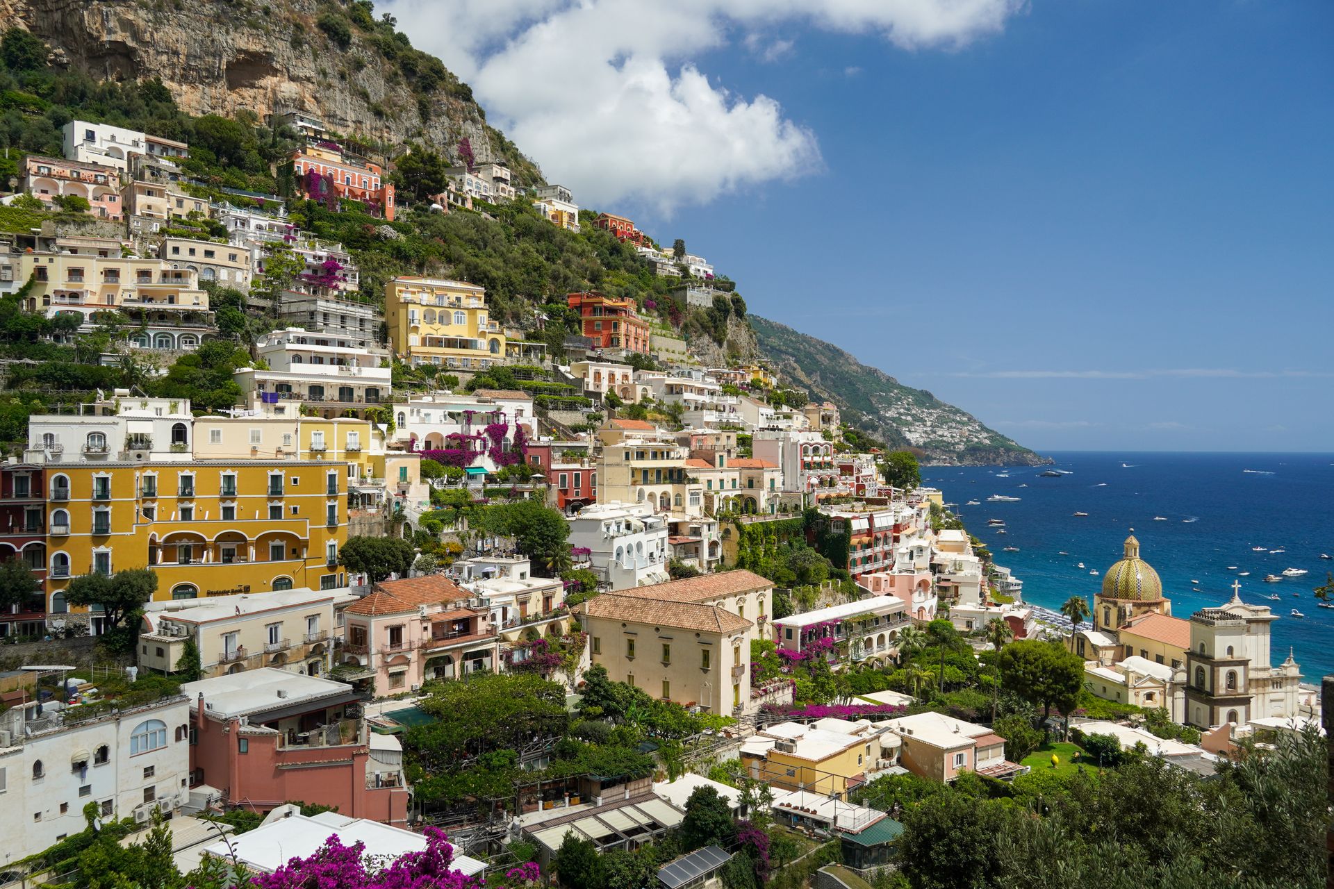 Panoramablick auf Positano mit bunten Häusern, steiler Küste und blauem Mittelmeer