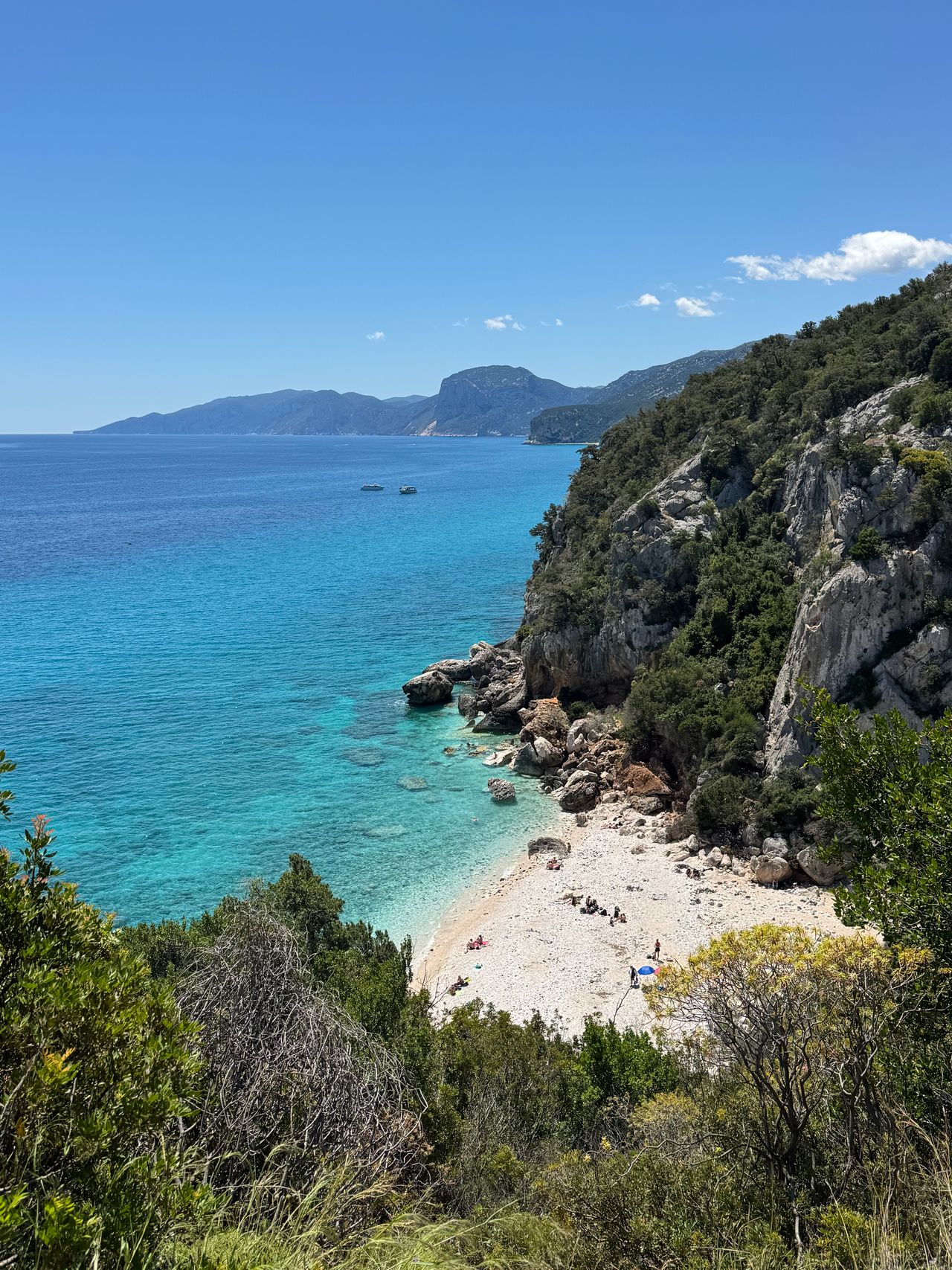 Gallipoli in Apulien mit Menschen im Wasser, blauem Meer und weißer Altstadt auf einer historischen Stadtmauer